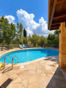 a large swimming pool with blue water at Koutsini Villa in Pano Akourdalia