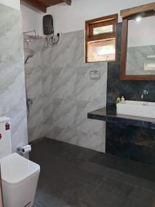 a bathroom with a white toilet and a sink at Ruwan's HomeStay in Matale