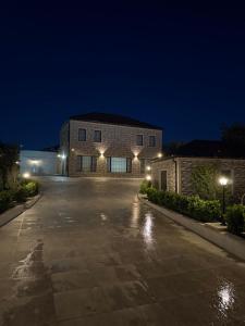 a brick building with lights in a driveway at night at Novxanı Villa in Baku
