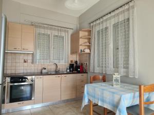 a kitchen with a table with a blue table cloth on it at Marinas house in Vaia