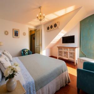 ein Schlafzimmer mit Bett, Fernseher und Sofa in der Unterkunft Villa Lorelei in Massa Lubrense