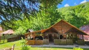 a large wooden house with a tree at Cabana Pinolera in Boga