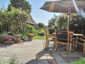 a table and chairs with an umbrella on a patio at 4 Bed in Corfe Castle oc-ic126 in Corfe Castle