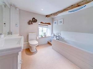 a bathroom with a toilet and a tub and a sink at 4 Bed in Corfe Castle oc-ic126 in Corfe Castle +8 photos