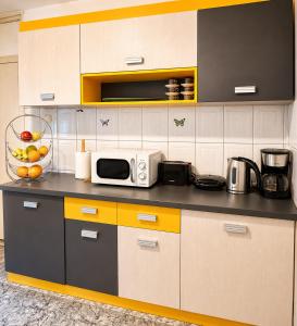 a kitchen with a microwave and fruit on the counter at Reyna Breeze Apartment in Constanţa
