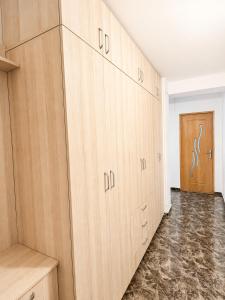 a row of wooden cabinets in a room with a door at Reyna Breeze Apartment in Constanţa