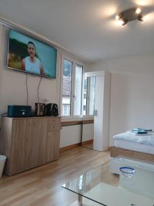 a living room with a flat screen tv on a wall at Zimmer mit Bad in Bühler