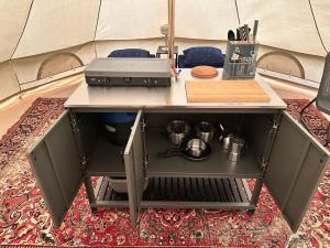 a kitchen island with a stove and a grill at Glamping de Hof van Eeden in Warmond +30 photos