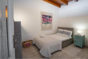 a bedroom with a bed and a painting on the wall at Beachfront House Pythagorion in Pythagoreio +39 photos