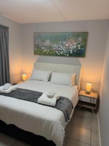 ein Schlafzimmer mit einem Bett, auf dem zwei Handtücher liegen in der Unterkunft Elevare suites in Nelspruit + 45 Fotos
