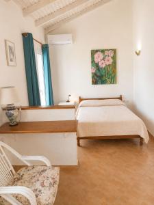 a bedroom with a bed and a chair in it at Sea & Sun in Gialova