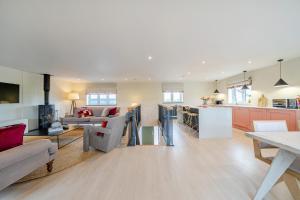 a living room and kitchen with a couch and a table at Bell House in Amlwch