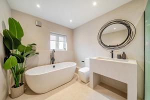 a bathroom with a white tub and a mirror at Bell House in Amlwch +45 photos