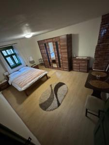 a bedroom with a bed and a rug on the floor at Căsuța din vale in Râșca