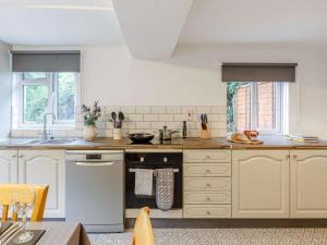 a kitchen with white cabinets and a sink at 3 Bed in Cullompton oc-85389 in Willand +17 photos