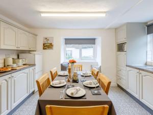 a dining room with a table and chairs in a kitchen at 3 Bed in Cullompton oc-85389 in Willand