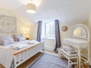 a bedroom with a white bed and a chair at 3 Bed in Cullompton oc-85389 in Willand
