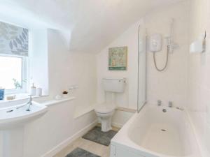 a white bathroom with a toilet and a sink at 3 Bed in Cullompton oc-85389 in Willand