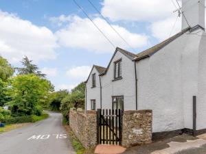 a white house with a gate on the side of a road at 3 Bed in Cullompton oc-85389 in Willand