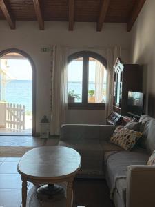 a living room with a couch and a table at Beachfront House Pythagorion in Pythagoreio