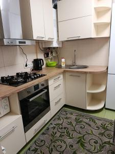 a kitchen with white cabinets and a stove top oven at Fontanka Apartment in Fontanka
