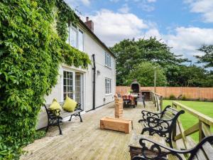 a wooden deck with benches and a house at 6 Bed in Filey oc-94524 in Reighton