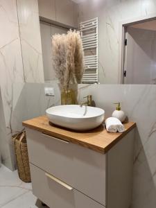 a bathroom with a white sink on a wooden counter at Pino SeaView II in Gdańsk