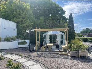 a gazebo with a picnic table in a garden at Siam Homestay in Mölndal