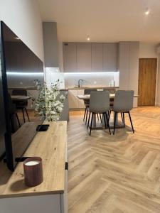 a kitchen and dining room with a table and chairs at Pino SeaView II in Gdańsk +3 photos