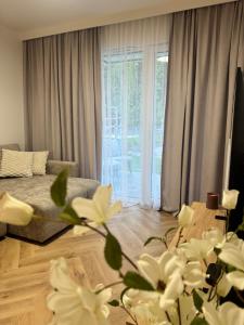 a living room with white flowers in front of a window at Pino SeaView II in Gdańsk