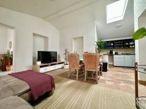 a living room with a bed and a table with chairs at Modern apartment with space for 6 in Weißenfels