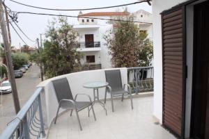 a balcony with chairs and a table on a balcony at Solis Apartments in Kallithea Halkidikis