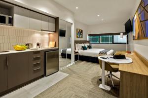 a kitchen and a bedroom with a bed at Quest Macquarie Park in Sydney