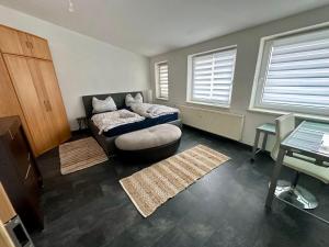 a bedroom with a bed and a table and windows at Modern apartment with space for 6 in Weißenfels