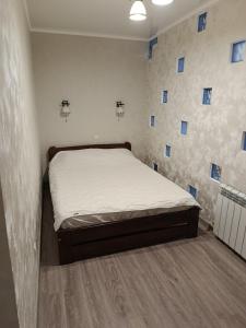 a bed in a room with blue squares on the wall at Fontanka Apartment in Fontanka