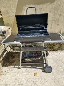 a barbecue grill sitting on a stand on the sidewalk at Casa sul fiume con giardino e terrazza in Pianello