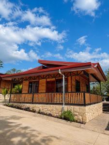 a log cabin building with a red roof at Cabaña Cadete in San Pedro