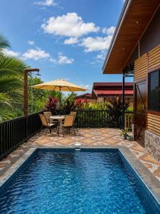 a pool with a table and an umbrella next to a house at Cabaña Cadete in San Pedro