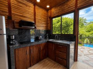a kitchen with a sink and a large window at Cabaña Cadete in San Pedro