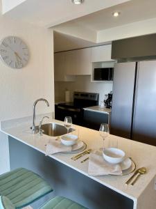 a kitchen with a sink and a counter with plates and glasses at Marias Apartment Parque Mateo in El Rodeo
