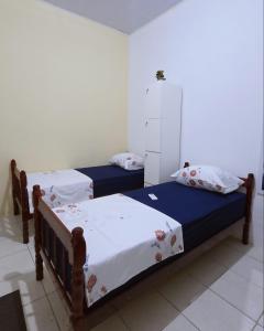 two twin beds in a room at Home Hostel Maceió in Maceió