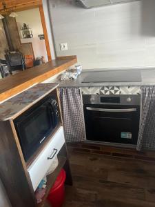 a kitchen with a stove and a microwave at La Era de Sandra in Sonseca