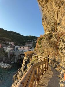 a wooden bridge over a river next to a city at Dreaming Rooms in Riomaggiore +23 photos