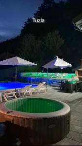 a swimming pool with umbrellas and chairs and a swimming pool at Villa Aqua Tuzla in Drenovik +13 photos