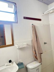 a bathroom with a white toilet and a sink at Chalé Mar Aberto in Atins