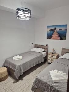 a bedroom with two beds and a picture on the wall at Flaburiotis House in Dhriopís