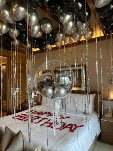 a room with a bed with a bunch of silver balloons at Khelo khaao in Jabalpur
