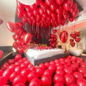 a bunch of red balloons in a room with a cake at Khelo khaao in Jabalpur
