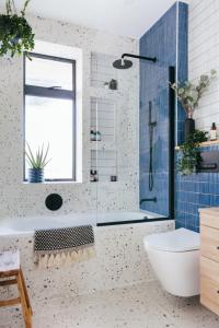 a bathroom with a tub and a toilet and a window at Khelo khaao in Jabalpur