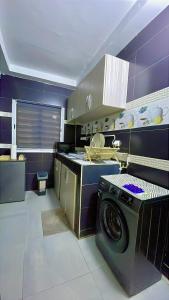 a kitchen with a washing machine and a stove at La case Dytobi Mermoz in Dakar